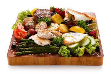 Various meat and vegetables served on cutting board
