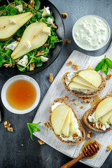 Fresh sweet Pears salad and bruschetta with cottage cheese, walnut on white board.