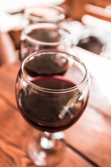 Three glasses of red wine on the vibrant restaurant background. Selective focus.