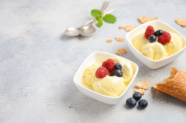 Vanilla ice cream with fresh berries on concrete background, selective focus, copy space