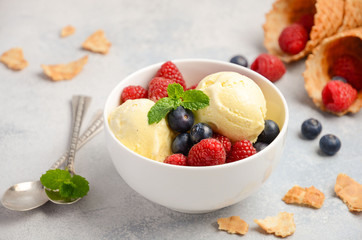Vanilla ice cream with fresh berries on concrete background, selective focus