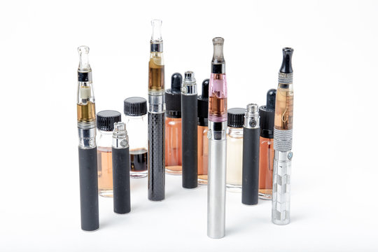 Electronic cigarettes with e-juice bottles on white background