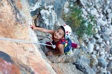 Little Girl doing Rock Climbing Training on vertical Wall