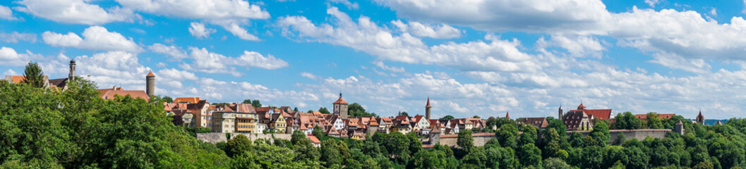 Fototapeta na wymiar Rothenburg ob der Tauber Skyline unter weiß-blauem Himmel als Panoramafoto