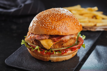 burger served with fries on stone table