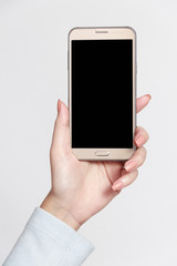Isolated female hand holding a phone with white background.