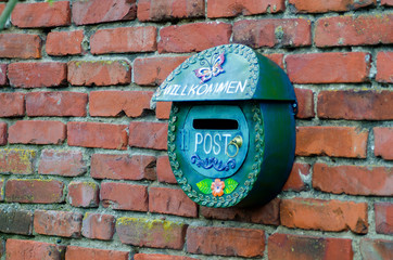 Green Postal Box against red Brick wall