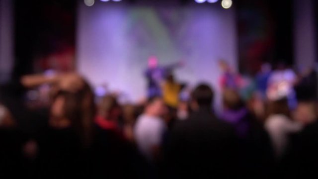 A crowd of people dancing at a rock concert. blurred image. Out of focus