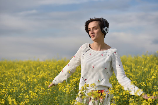 Caucasian girl listening to music with headphone in the outdoors