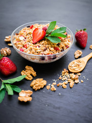 Oatmeal porridge with blueberries, strawberries, mint and muesli on wooden background. Top view. Diet breakfast.