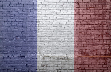 French flag over an old dirty brick wall