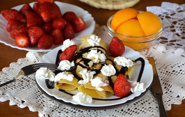 Sweet homemade pancakes with apricots, strawberries, chocolate and whipped cream. 