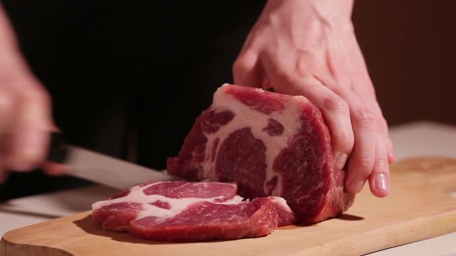 cut the meat of a black knife on black background. Do not want to cook in the kitchen, a wooden Board sharp meat. Beef, pork, meat.