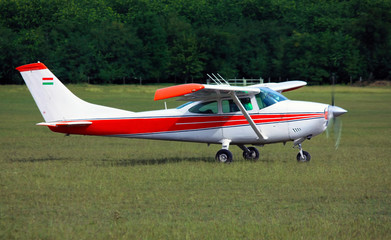 Light red white school airplane on airport grass before take off