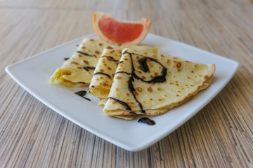 Dessert of pancakes on plate on table with eggs