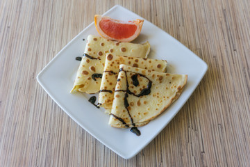 Dessert of pancakes on plate on table with eggs
