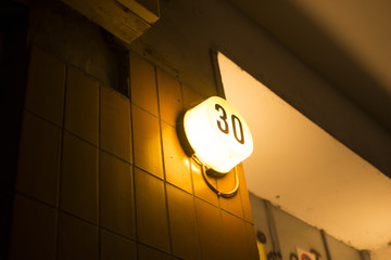 Light bulbs are bright at night time. Wall house lamp on cement wall in the city park garden. Berlin