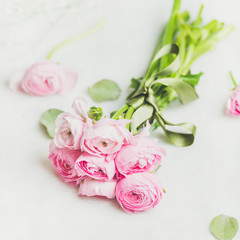 Light pink spring ranunkulus flowers bouquet on white marble background, selective focus, copy space, square crop. Spring greeting card concept