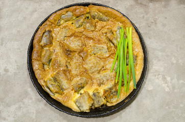 Sliced ​​roasted fish filled with an omelette in a pan, cooked in the oven.