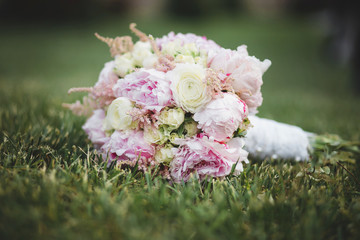 Beautiful  wedding bouquet laying on the green lawn