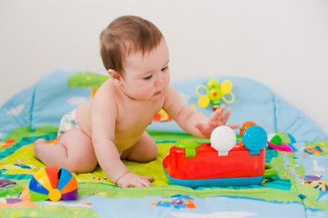 baby playing with educational toys lying