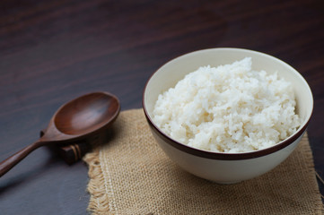 Thai rice in bowl with wooden spoon on table