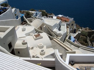 Fototapeta na wymiar Roofs of the island of Santorini/View of the roofs and walls of buildings in Santorini, Greece, Cyclades. Typical white and blue architecture. From travels in the Mediterranean