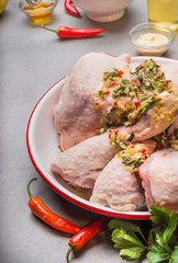 Raw chicken legs cooking with marinate, oil and spices, close up