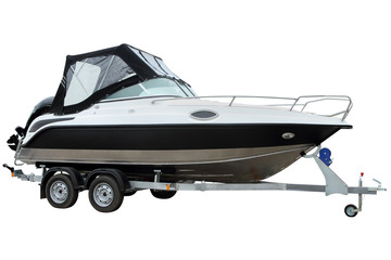 Modern motor boat with canvas top on a trailer for transportation.