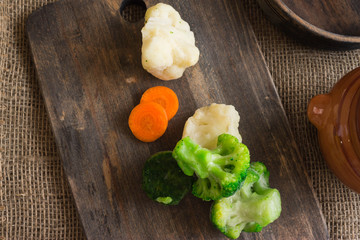 Frozen vegetables on a wooden cutting board. Healthy food. The concept of vegetarianism.