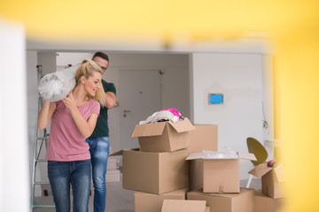 Fototapeta premium couple carrying a carpet moving in to new home
