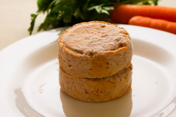 Frozen carrot patties on a white plate and ingredients. The concept of a healthy diet. Vegetarian cuisine.