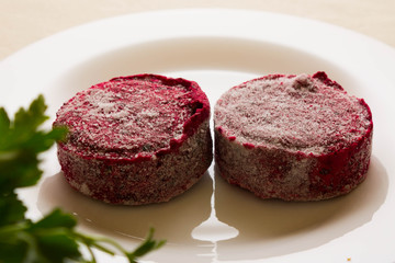 Frozen beet cutlets on a white plate. The concept of a healthy diet. Vegetarian dish.
