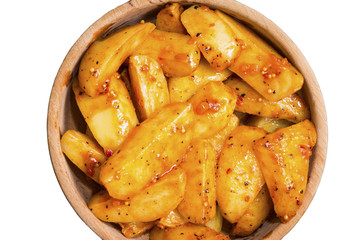 Baked potatoes with spices in a wooden bowl on a white isolated background