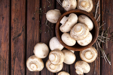 Mushrooms champignon on wooden background. Top view. Copy space.