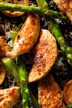 Grilled chicken breast, green asparagus and lemon, top view