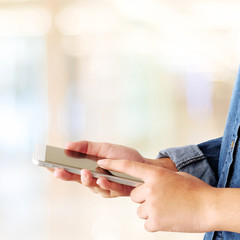 Hand using smart phone over blur bokeh light background, business and technology concept, digital marketing, seo, e-commerce, lifestyle, social media network, internet of things