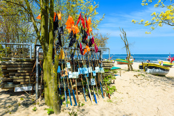 Network fishing drying on the beach in sunny day. Baltic Sea and fishing boats in background. Sopot, Poland. - obrazy, fototapety, plakaty