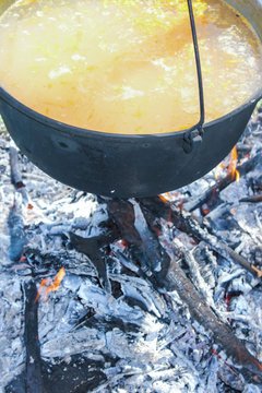 Fish soup boils in cauldron, food background