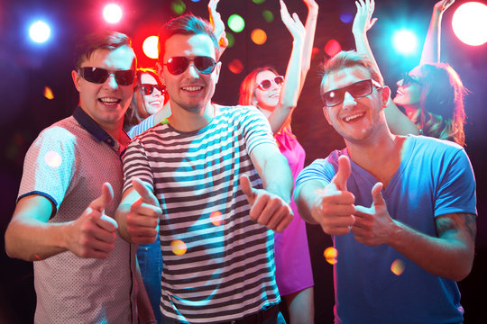 Group of happy friends showing OK sign