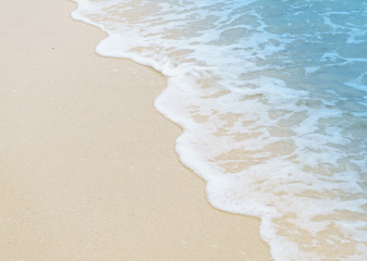 Soft wave of blue ocean on sandy beach. Background.