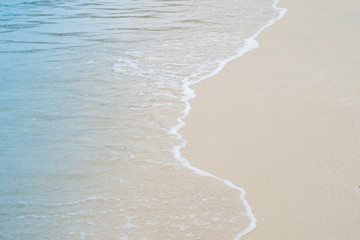 Soft wave of blue ocean on sandy beach. Background.