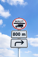 Schild Mautpflicht mit Entfernungs- und Richtungsangabe