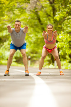 Fitness couple stretching outdoors in park