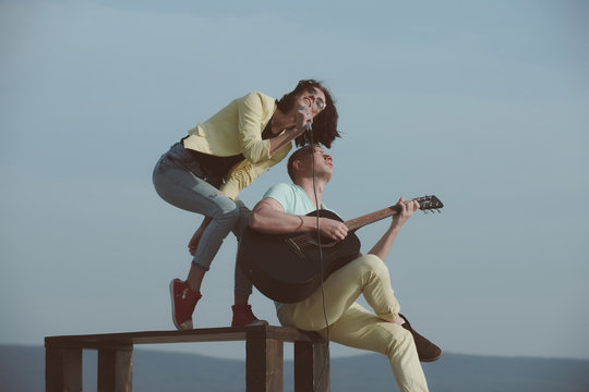 music band of man and woman with guitar and microphone