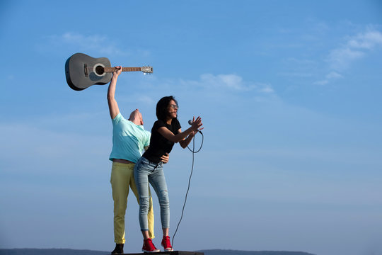 music band of man and woman with guitar and microphone