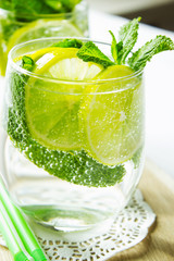 Homemade lemonade with lemon and mint on the kitchen table. Selective focus. Vertical.