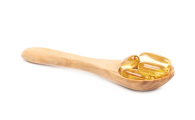Wooden spoon full of softgel pills