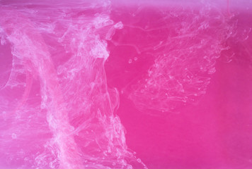 Abstract colored background. Pink smoke, ink in water, the patterns of the universe. Abstract movement, frozen multicolor flow of paint. Horizontal photo with soft focus, blurred backdrop.