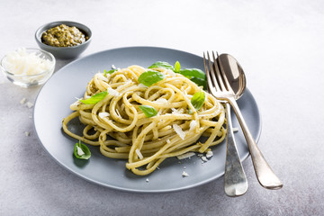 Homemade linguine pasta with green pesto and basil. Italian healthy food concept with copy space.